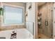 Bright and airy bathroom featuring a soaking tub, separate shower and large window at 305 Cranmore Pl, Villa Rica, GA 30180