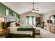 Bright main bedroom featuring a vaulted ceiling, plush carpet, a ceiling fan, and green accent wall at 305 Cranmore Pl, Villa Rica, GA 30180