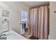 Bathroom featuring a shower with curtain, adjacent sink, and towel rack by a window at 5997 Wildcreek Rd, Sugar Hill, GA 30518
