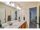 Bathroom featuring double sinks with bronze fixtures, a large mirror, and an adjacent room at 5997 Wildcreek Rd, Sugar Hill, GA 30518