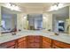 Bathroom featuring double sinks with a marble countertop, and an open doorway to the bedroom and tub at 5997 Wildcreek Rd, Sugar Hill, GA 30518