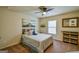 Comfortable bedroom featuring a ceiling fan, decorative wall art, a large window, and plush carpet at 5997 Wildcreek Rd, Sugar Hill, GA 30518