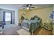 Spacious bedroom featuring a ceiling fan, dresser, decorative mirror, and plush carpet at 5997 Wildcreek Rd, Sugar Hill, GA 30518