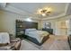 Spacious bedroom featuring a large bed, custom headboard with shelves, and soft carpet at 5997 Wildcreek Rd, Sugar Hill, GA 30518