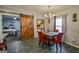 Dining area with a wooden table and chairs, complemented by modern lighting and a glimpse into the bedroom at 5997 Wildcreek Rd, Sugar Hill, GA 30518