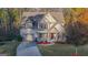 Charming home featuring a two-car garage, red shutters, and landscaped front yard at 5997 Wildcreek Rd, Sugar Hill, GA 30518