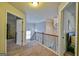 Hallway featuring carpet flooring, wood railing, a modern chandelier, and natural light at 5997 Wildcreek Rd, Sugar Hill, GA 30518