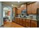 Modern kitchen featuring stainless steel appliances, wooden cabinets, and granite countertops at 5997 Wildcreek Rd, Sugar Hill, GA 30518