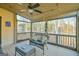 Cozy screened porch with seating area, fan, and a view of the surrounding trees at 5997 Wildcreek Rd, Sugar Hill, GA 30518