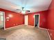 A spacious bedroom features a ceiling fan, bright red walls, neutral carpet, and an attached bathroom at 209 East Wilson St # 25, Villa Rica, GA 30180