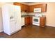 Functional kitchen featuring white appliances, brown wood cabinets and vinyl floors at 209 East Wilson St # 25, Villa Rica, GA 30180