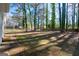 Backyard with tall trees and a grass lawn, framed by a wooden fence, providing privacy at 403 Sandown Dr, Peachtree City, GA 30269