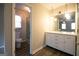 Bright bathroom featuring a marble countertop vanity, modern lighting, and a glimpse of a tiled shower at 403 Sandown Dr, Peachtree City, GA 30269