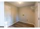 Neutral laundry room with white door, shelving, and plank flooring at 403 Sandown Dr, Peachtree City, GA 30269