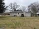 View of backyard with back of the house featuring neutral siding and a large grassy area at 245 Carole Dr, Oxford, GA 30054