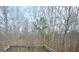 Backyard view of dense trees and woods with wooden deck railing at 7491 Hilltop Way, Atlanta, GA 30349