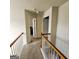 Hallway area with doors leading into different rooms and a wooden railing at 7491 Hilltop Way, Atlanta, GA 30349