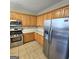 Well-lit kitchen featuring stainless steel appliances and oak cabinetry at 7491 Hilltop Way, Atlanta, GA 30349