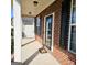 Covered front porch with brick siding, a 'Welcome' doormat, and dark window shutters at 7491 Hilltop Way, Atlanta, GA 30349