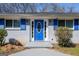 Charming home entrance featuring a bright blue front door, matching shutters and manicured shrubs at 1393 Vesta Ave, Atlanta, GA 30344