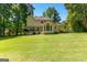 Expansive backyard featuring a large lawn, mature trees, and a raised deck, perfect for outdoor living at 423 Holly Grove Church Rd, Peachtree City, GA 30269