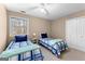 Bedroom featuring two beds with blue accents, large window and a ceiling fan at 423 Holly Grove Church Rd, Peachtree City, GA 30269