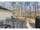 Wooden deck with metal furniture, nestled in a wooded backyard setting at 423 Holly Grove Church Rd, Peachtree City, GA 30269