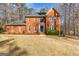Traditional red brick home with a well-manicured lawn and mature trees in a suburban setting at 423 Holly Grove Church Rd, Peachtree City, GA 30269
