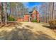 Traditional red brick home with a well-manicured lawn and mature trees in a suburban setting at 423 Holly Grove Church Rd, Peachtree City, GA 30269
