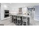 The kitchen features bright white cabinets, stainless steel appliances, stone countertops, and eat-in seating at the island at 423 Holly Grove Church Rd, Peachtree City, GA 30269