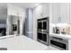 Eat-in kitchen features white cabinets, stainless steel appliances, stone countertops, and a grey island at 423 Holly Grove Church Rd, Peachtree City, GA 30269