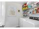 A well-organized laundry area features shelving and plenty of natural light from the window at 423 Holly Grove Church Rd, Peachtree City, GA 30269