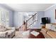Bright living room featuring hardwood floors, stylish furniture, and staircase access at 423 Holly Grove Church Rd, Peachtree City, GA 30269