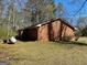 Side view of the brick home showcasing its simple architectural design and backyard setting at 924 Polk Rd, Moreland, GA 30259