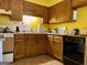 Functional kitchen with wood cabinets, essential appliances, and bright yellow walls at 924 Polk Rd, Moreland, GA 30259