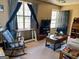Cozy living room with large windows, a rocking chair, and comfortable furnishings at 924 Polk Rd, Moreland, GA 30259