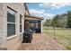 Spacious backyard featuring a brick patio, grill, and a screened porch, perfect for outdoor living and entertaining at 3225 Alhambra Cir, Hampton, GA 30228