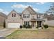 Two-story brick home with attached garage, manicured landscaping, and covered front porch at 3225 Alhambra Cir, Hampton, GA 30228
