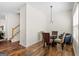 Bright dining area with hardwood floors, modern lighting, and staircase access at 2205 Hyssop Way, Buford, GA 30519