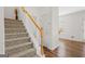 Carpeted staircase featuring a wooden handrail and abundant natural light at 2205 Hyssop Way, Buford, GA 30519