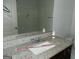 Bathroom sink with granite countertop and a mirror reflecting a shower with shelving at 7484 Knoll Hollow Rd, Lithonia, GA 30058