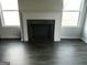 Living room featuring a fireplace, hardwood flooring, and large windows for natural light at 7484 Knoll Hollow Rd, Lithonia, GA 30058