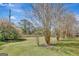 Large backyard featuring mature crape myrtles and a full, green lawn with a wood fence in the background at 912 Shadow Ridge Cir, Stockbridge, GA 30281