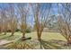 Large backyard featuring mature crape myrtles and a full, green lawn with a wood fence in the background at 912 Shadow Ridge Cir, Stockbridge, GA 30281