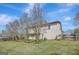 Backyard featuring home's exterior, green lawn, mature trees, and a wood fence in the background at 912 Shadow Ridge Cir, Stockbridge, GA 30281