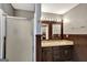 Bathroom featuring glass enclosed shower, double sinks, wooden framed mirrors, neutral counters, and wood paneled walls at 912 Shadow Ridge Cir, Stockbridge, GA 30281