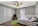 A bright bedroom with a dinosaur themed bed cover, closet, and a ceiling fan at 912 Shadow Ridge Cir, Stockbridge, GA 30281