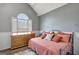 Bedroom with a gray wall, arched window, and a wooden dresser next to the bed at 912 Shadow Ridge Cir, Stockbridge, GA 30281