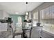 Bright dining area features a round glass table, four upholstered chairs, and multiple windows at 912 Shadow Ridge Cir, Stockbridge, GA 30281