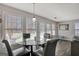 Sunlit dining area with a glass table, four gray chairs, and large windows offering natural light at 912 Shadow Ridge Cir, Stockbridge, GA 30281